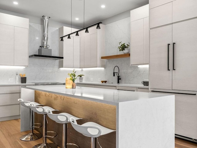 kitchen featuring a breakfast bar, modern cabinets, a kitchen island, and tasteful backsplash