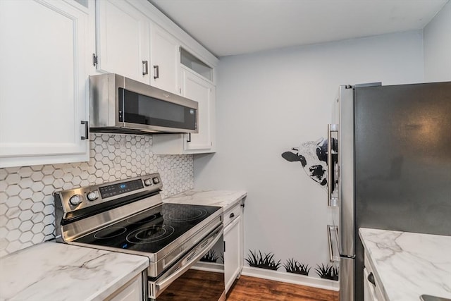 kitchen with decorative backsplash, light stone counters, wood finished floors, stainless steel appliances, and white cabinetry