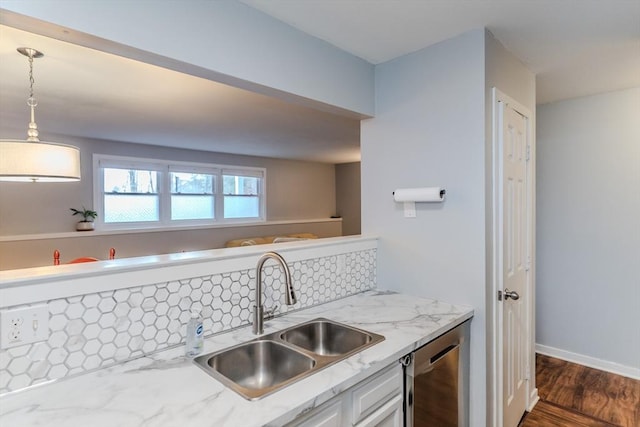 kitchen featuring white cabinets, a sink, light stone countertops, hanging light fixtures, and stainless steel dishwasher