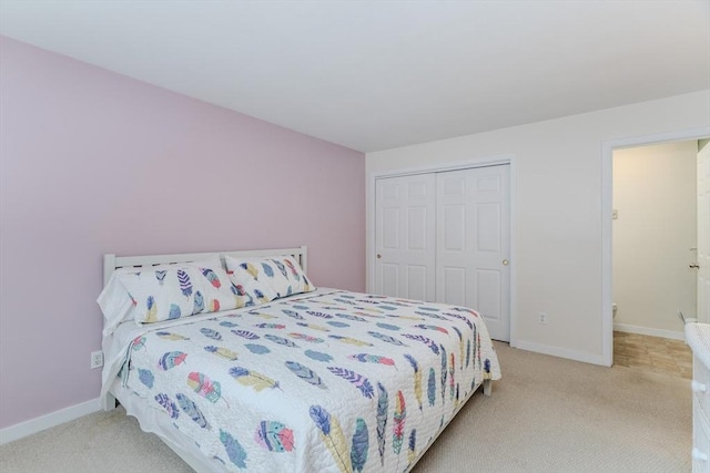 bedroom featuring light carpet, a closet, and baseboards