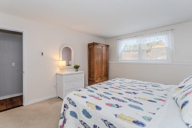 bedroom with light colored carpet and baseboards