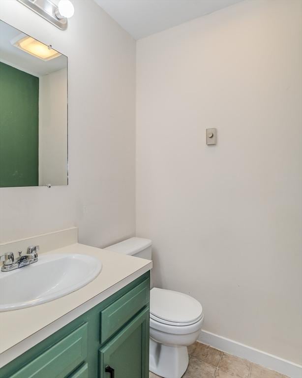 half bath featuring toilet, tile patterned flooring, baseboards, and vanity