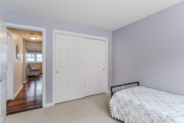 bedroom with a closet, carpet flooring, and baseboards