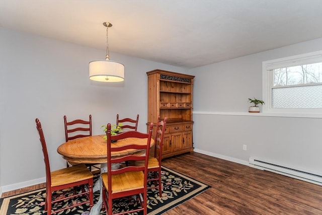 dining space with a baseboard heating unit, baseboards, and wood finished floors