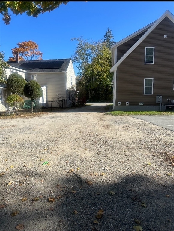 view of side of home with central AC unit and solar panels