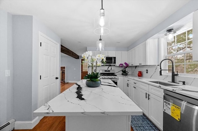 kitchen with pendant lighting, a kitchen island, white cabinetry, and stainless steel appliances