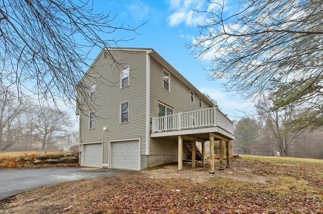 rear view of house with a garage and a wooden deck