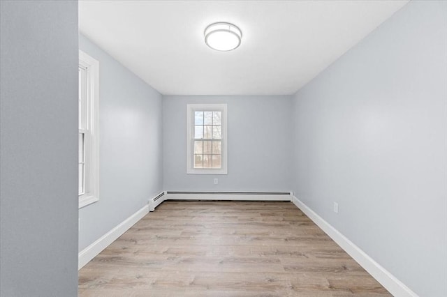 spare room with a baseboard radiator and light hardwood / wood-style flooring