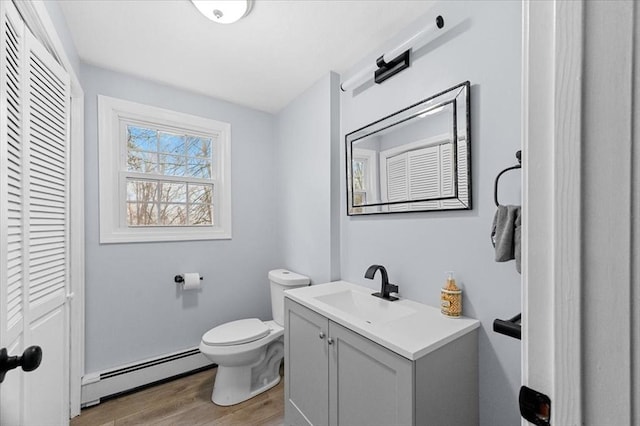 bathroom with baseboard heating, hardwood / wood-style floors, vanity, and toilet