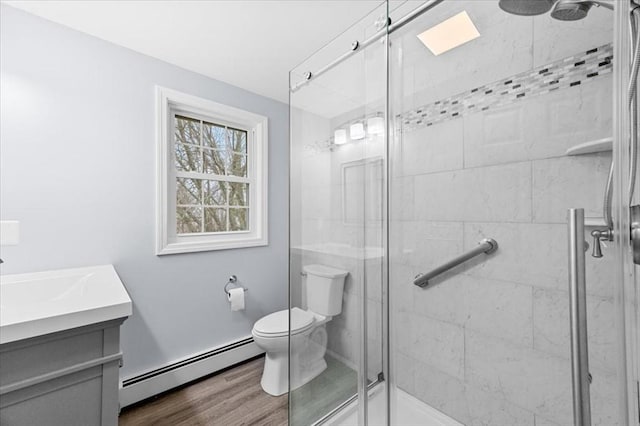 bathroom with an enclosed shower, vanity, wood-type flooring, a baseboard radiator, and toilet