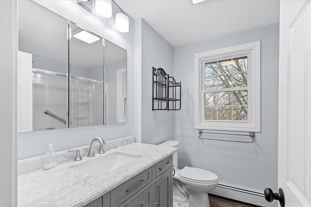 bathroom with toilet, a shower, vanity, and a baseboard radiator