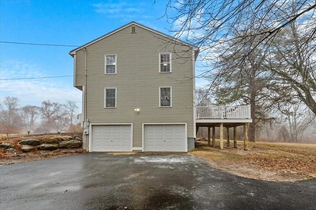 view of side of home with a garage and a wooden deck