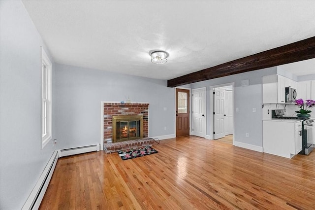 unfurnished living room featuring baseboard heating, light hardwood / wood-style flooring, beamed ceiling, and a brick fireplace