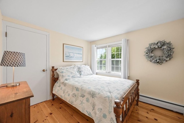 bedroom with baseboard heating and light wood-type flooring