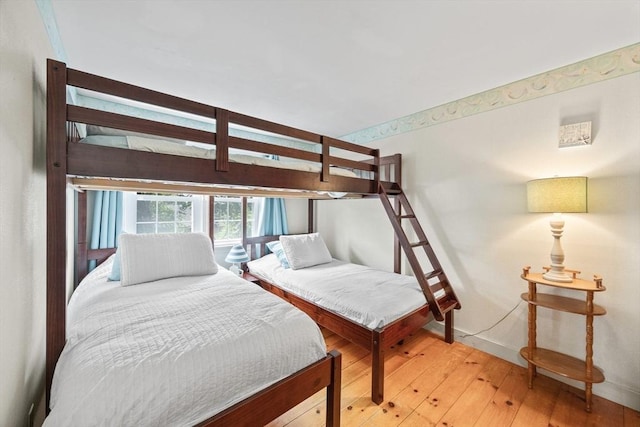bedroom with light wood-style flooring and baseboards