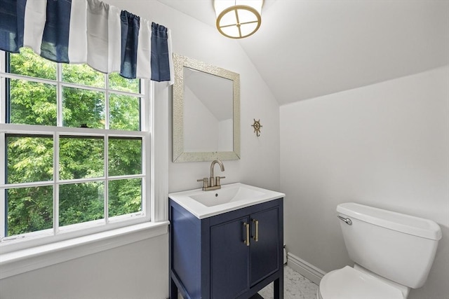 half bath with lofted ceiling, vanity, toilet, and baseboards