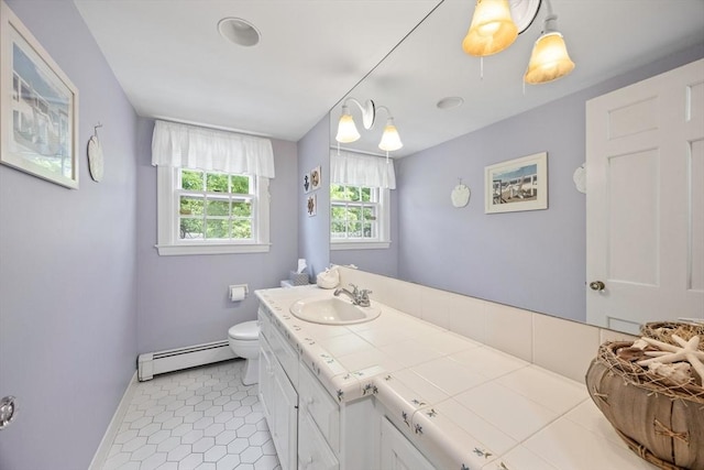 bathroom with a baseboard heating unit, baseboards, toilet, vanity, and tile patterned floors