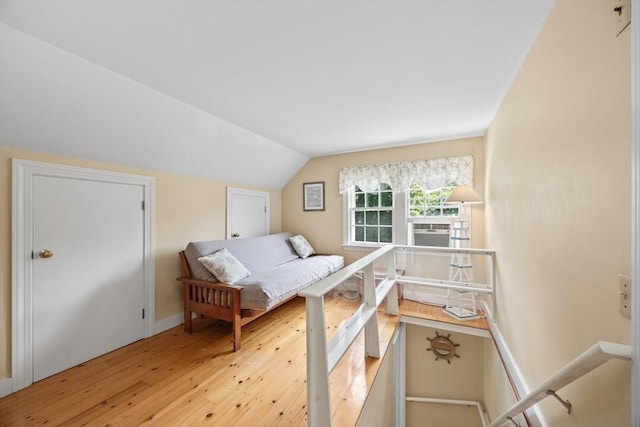 bedroom featuring hardwood / wood-style flooring, lofted ceiling, and baseboards