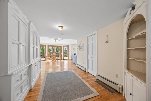 hall with a baseboard radiator, light wood finished floors, and built in features