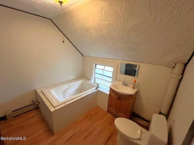full bath with vanity, wood finished floors, toilet, a jetted tub, and vaulted ceiling
