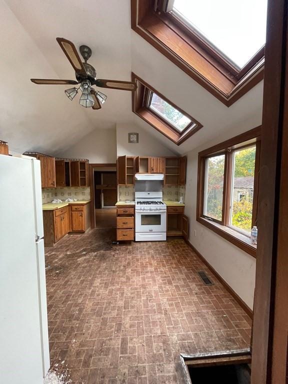 65 Beacon St, Melrose, MA 02176 - kitchen with lofted ceiling with skylight, ceiling fan, backsplash, and white appliances
