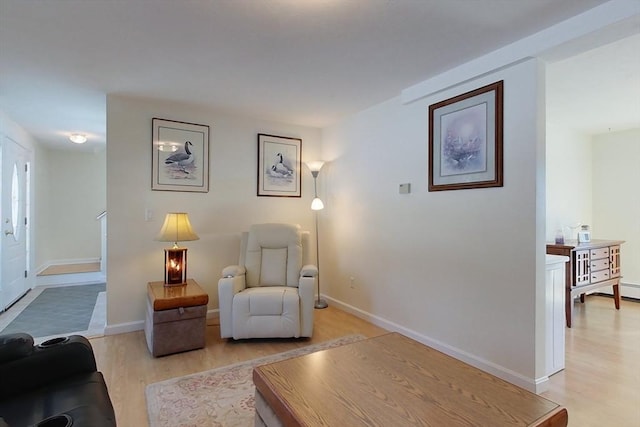 living area featuring light wood-style floors and baseboards