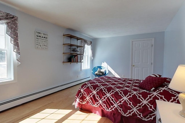 bedroom featuring baseboard heating and wood finished floors