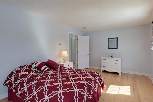 bedroom with baseboards and wood finished floors