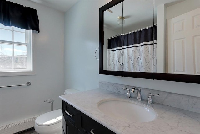 full bath featuring toilet, curtained shower, baseboard heating, and vanity