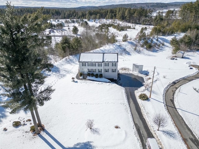 snowy aerial view featuring a view of trees