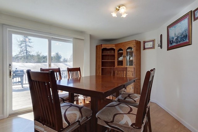 dining room featuring light wood-style flooring and baseboards