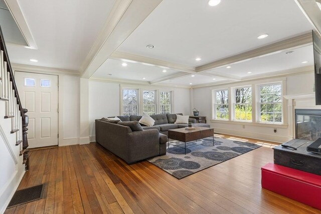 living area with visible vents, baseboards, wood-type flooring, and stairs