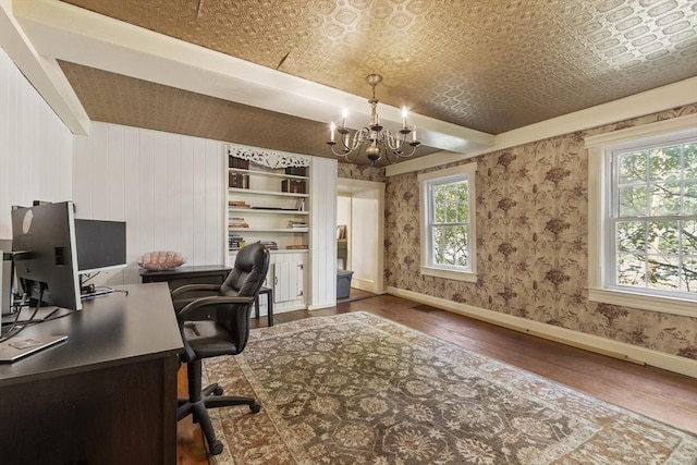 office with an inviting chandelier, baseboards, wood finished floors, and visible vents