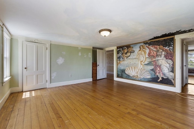 unfurnished room featuring baseboards, ornamental molding, and hardwood / wood-style flooring