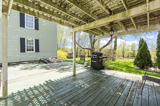 wooden deck featuring area for grilling, a pergola, and a yard