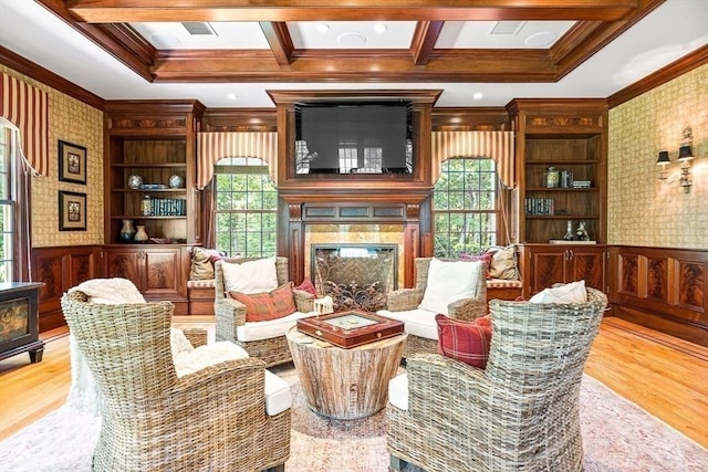 sitting room featuring crown molding, wainscoting, wood finished floors, and wallpapered walls