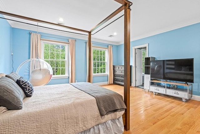 bedroom featuring baseboards, visible vents, ornamental molding, and wood finished floors