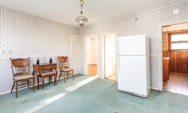 sitting room with carpet floors, wainscoting, and wallpapered walls