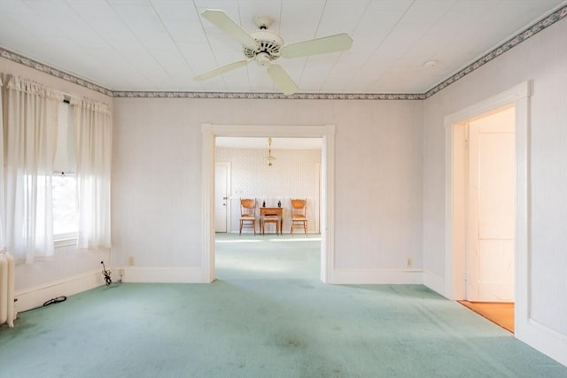 spare room with radiator, a ceiling fan, baseboards, and carpet floors