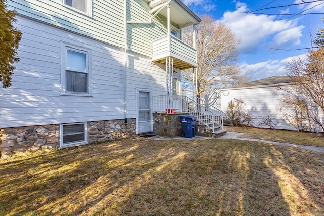 view of home's exterior featuring a yard and a balcony