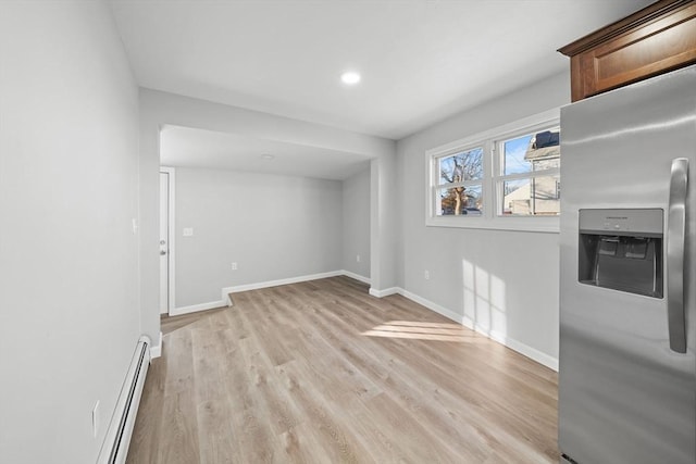 interior space with a baseboard heating unit and light wood-type flooring