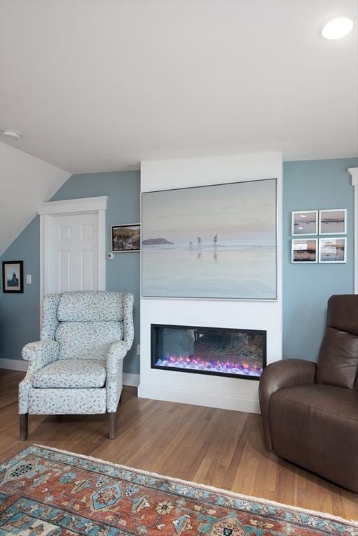 74 E Main St Unit 3, Gloucester, MA 01930 - living room featuring a glass covered fireplace, wood finished floors, baseboards, and vaulted ceiling