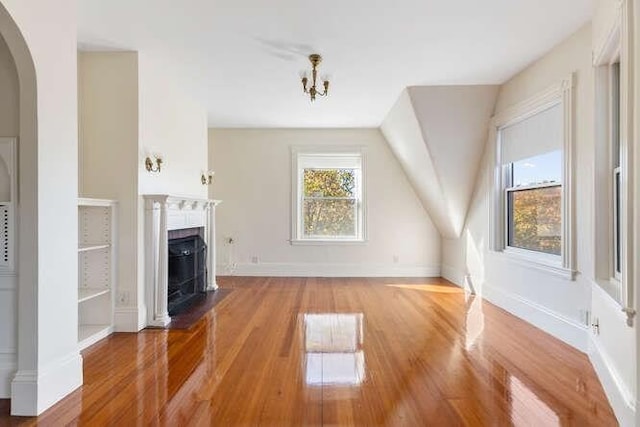 4-6 W St, Arlington, MA 02476 - unfurnished living room with wood finished floors, a fireplace with flush hearth, arched walkways, and baseboards