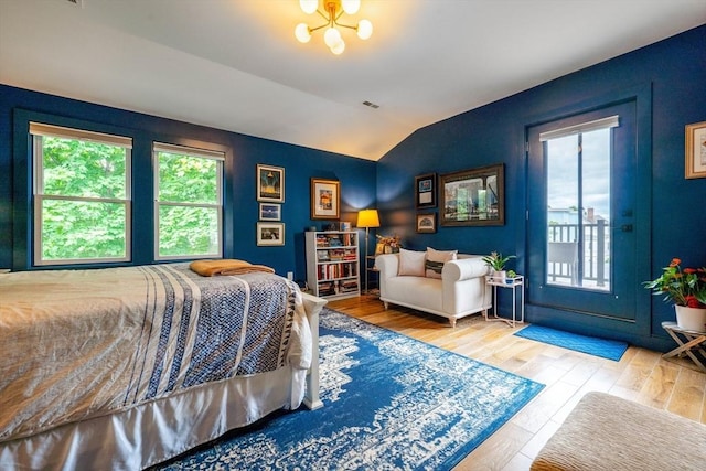 16 Walker St Unit 16, Medford, MA 02155 - bedroom with multiple windows, wood finished floors, vaulted ceiling, and access to outside