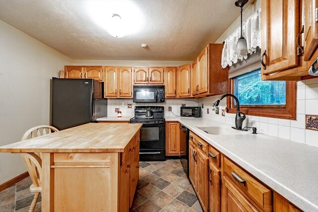 kitchen with black appliances, backsplash, dark tile patterned flooring, a breakfast bar, and sink