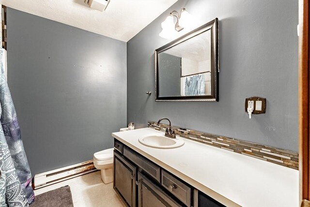 bathroom with a baseboard radiator, toilet, vanity, and tasteful backsplash