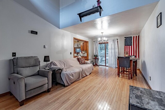 living room with an inviting chandelier and light wood-type flooring