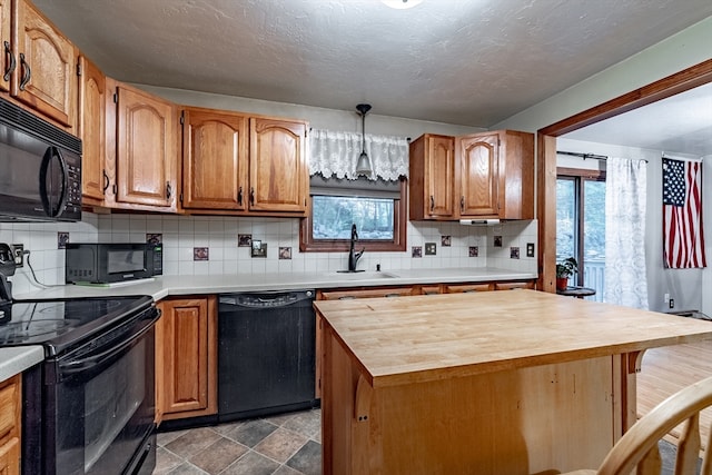 kitchen featuring black appliances, wooden counters, backsplash, and decorative light fixtures