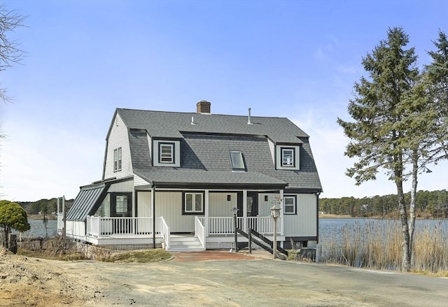 dutch colonial featuring a chimney, a gambrel roof, a shingled roof, and covered porch
