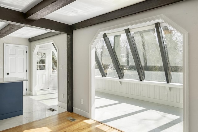 bonus room with visible vents, arched walkways, baseboards, and beam ceiling
